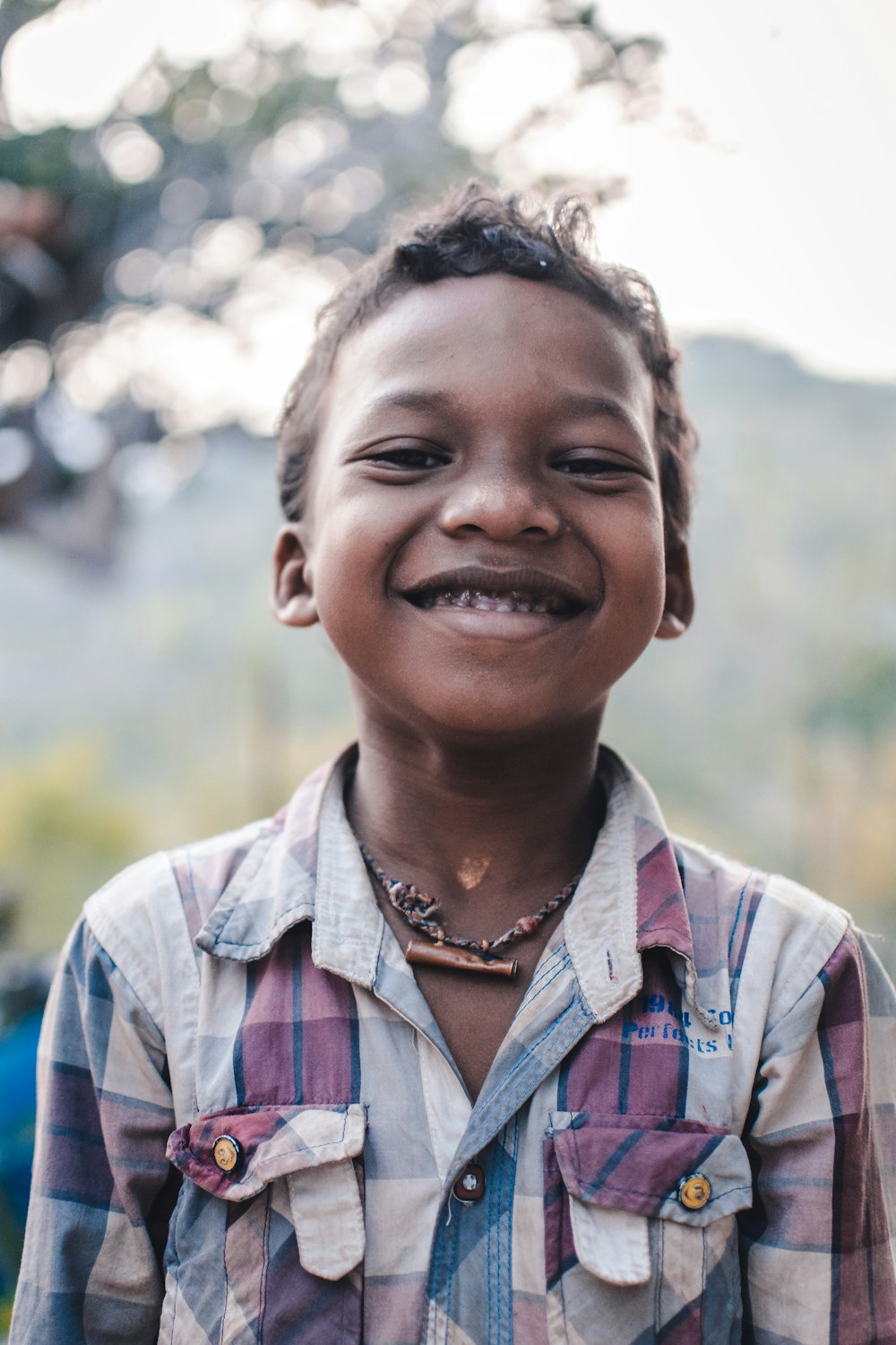 smiling woman in blue white and brown plaid button up shirt