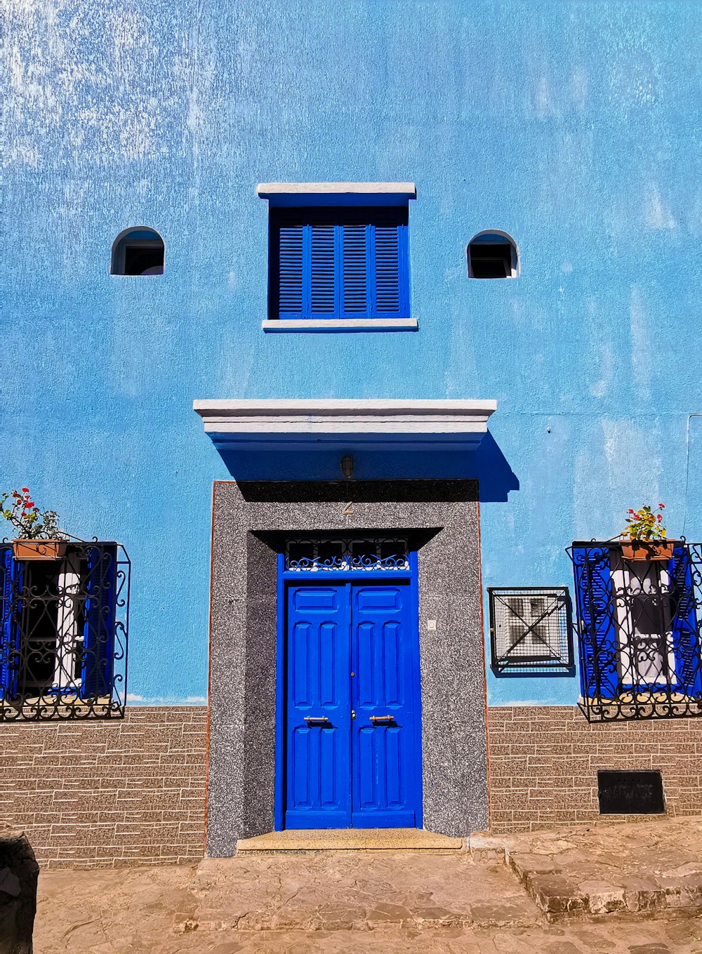 blue wooden door on blue concrete building