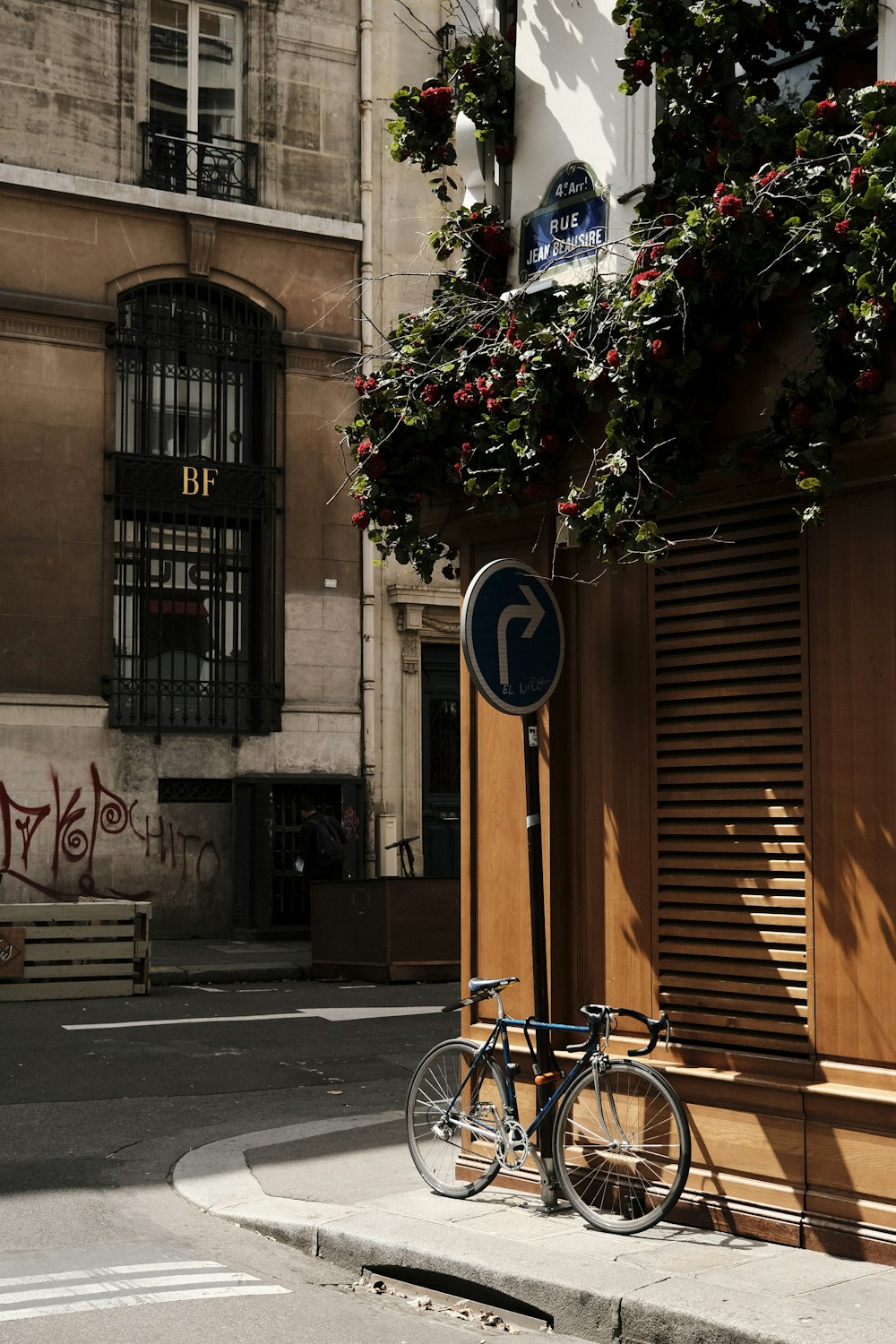 blue city bike parked beside brown concrete building during daytime