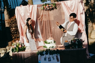 man and woman standing in front of cake