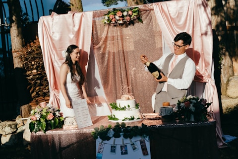 man and woman standing in front of cake