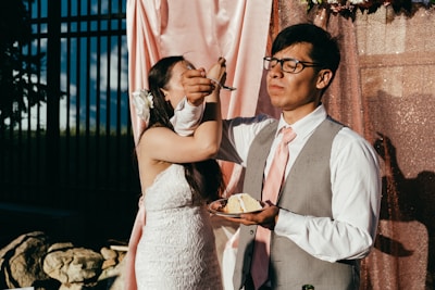 A cheerful cartoon bride and groom holding a platter of appetizers.