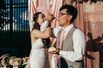 man in white suit kissing woman in white dress