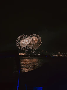 Colorful fireworks bursting over a night sky above a festive event venue.