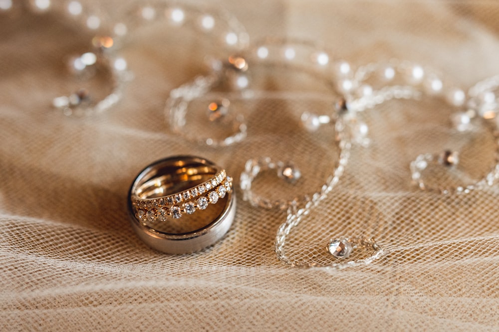 silver wedding band on white textile