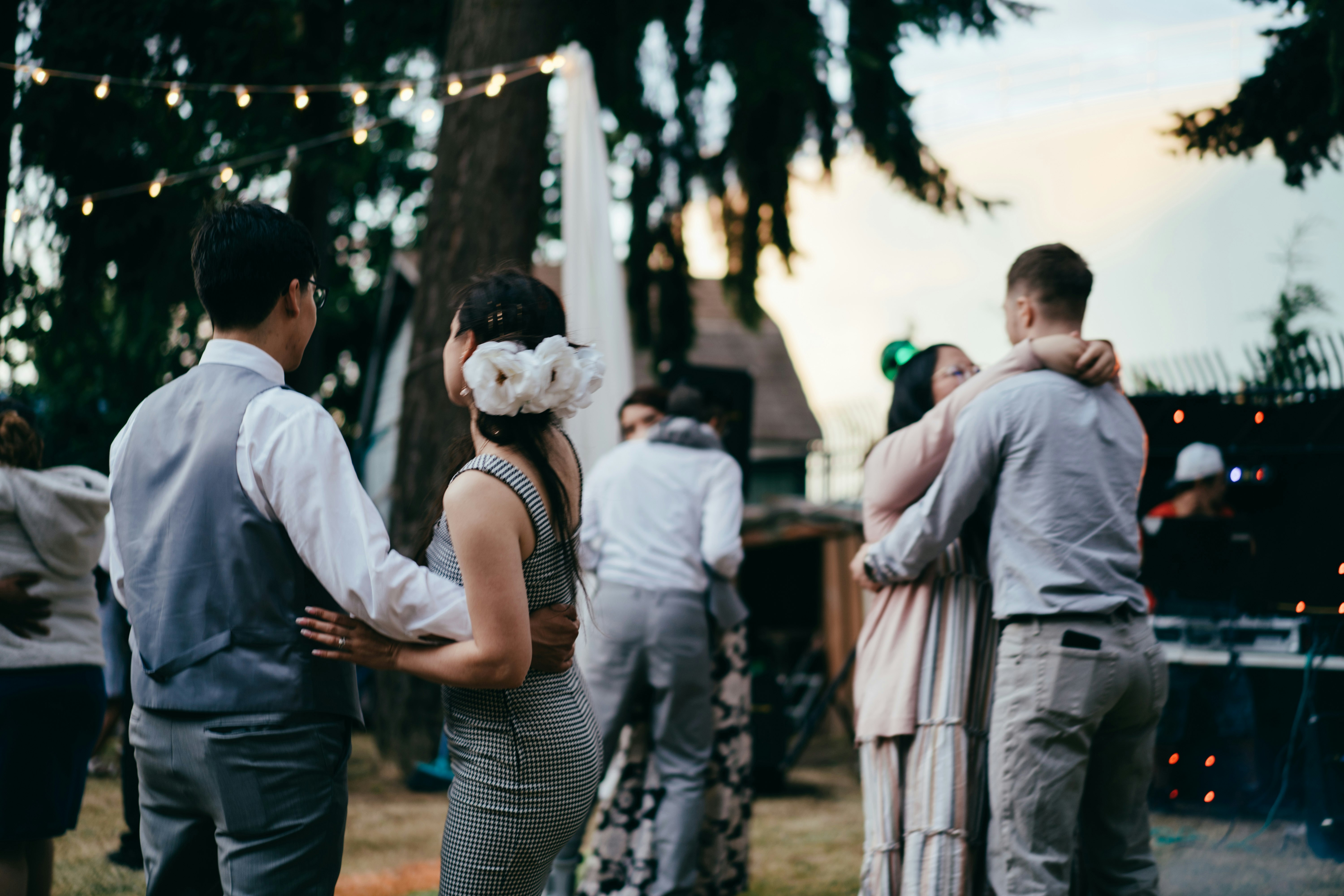 man in white dress shirt standing beside woman in white sleeveless shirt