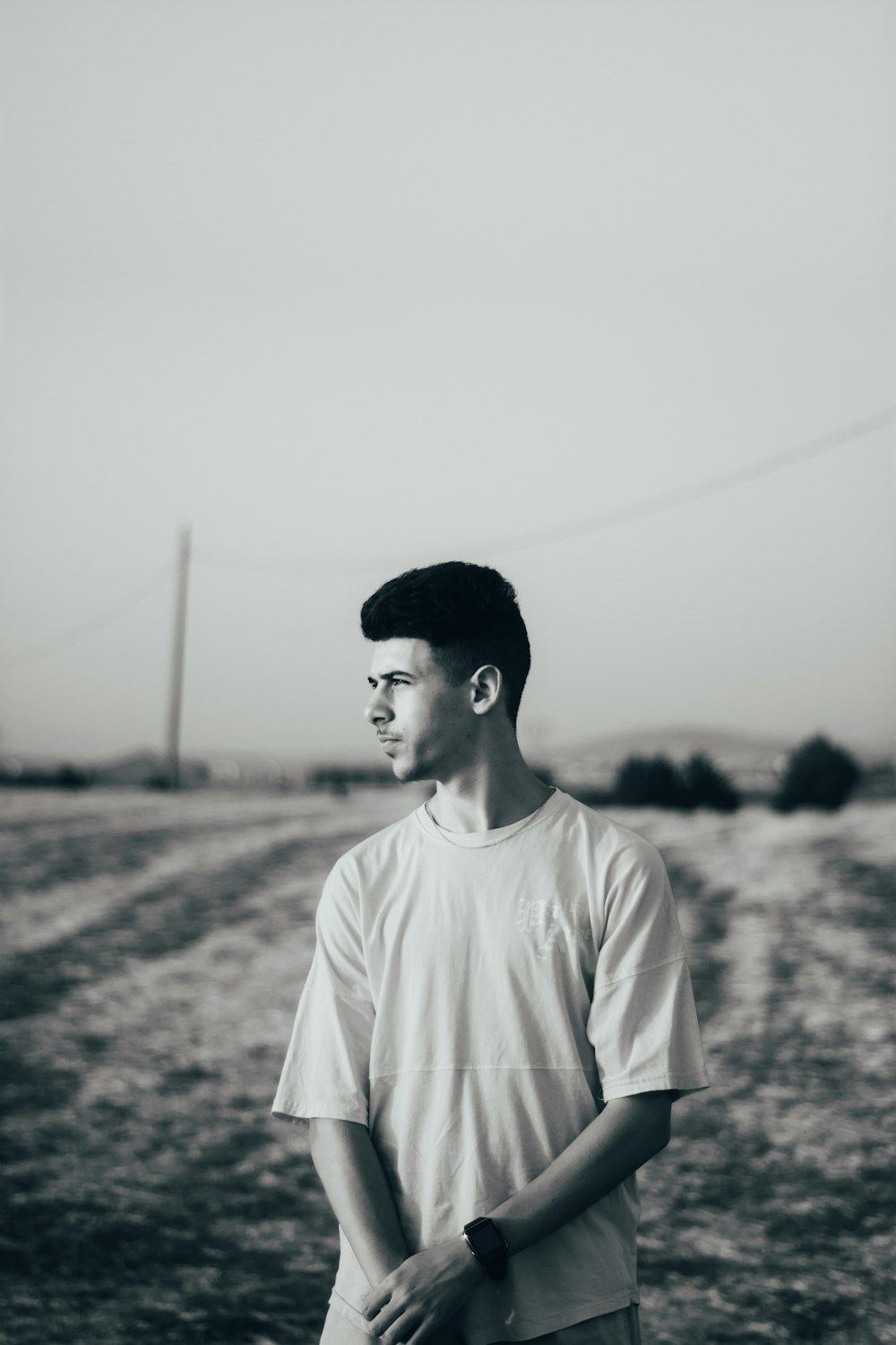 man in white crew neck t-shirt standing on field during daytime