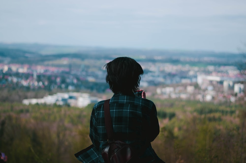 woman in black and red plaid shirt standing on grass field during daytime