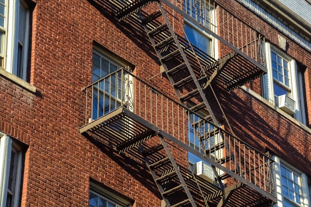 brown brick building with black metal staircase