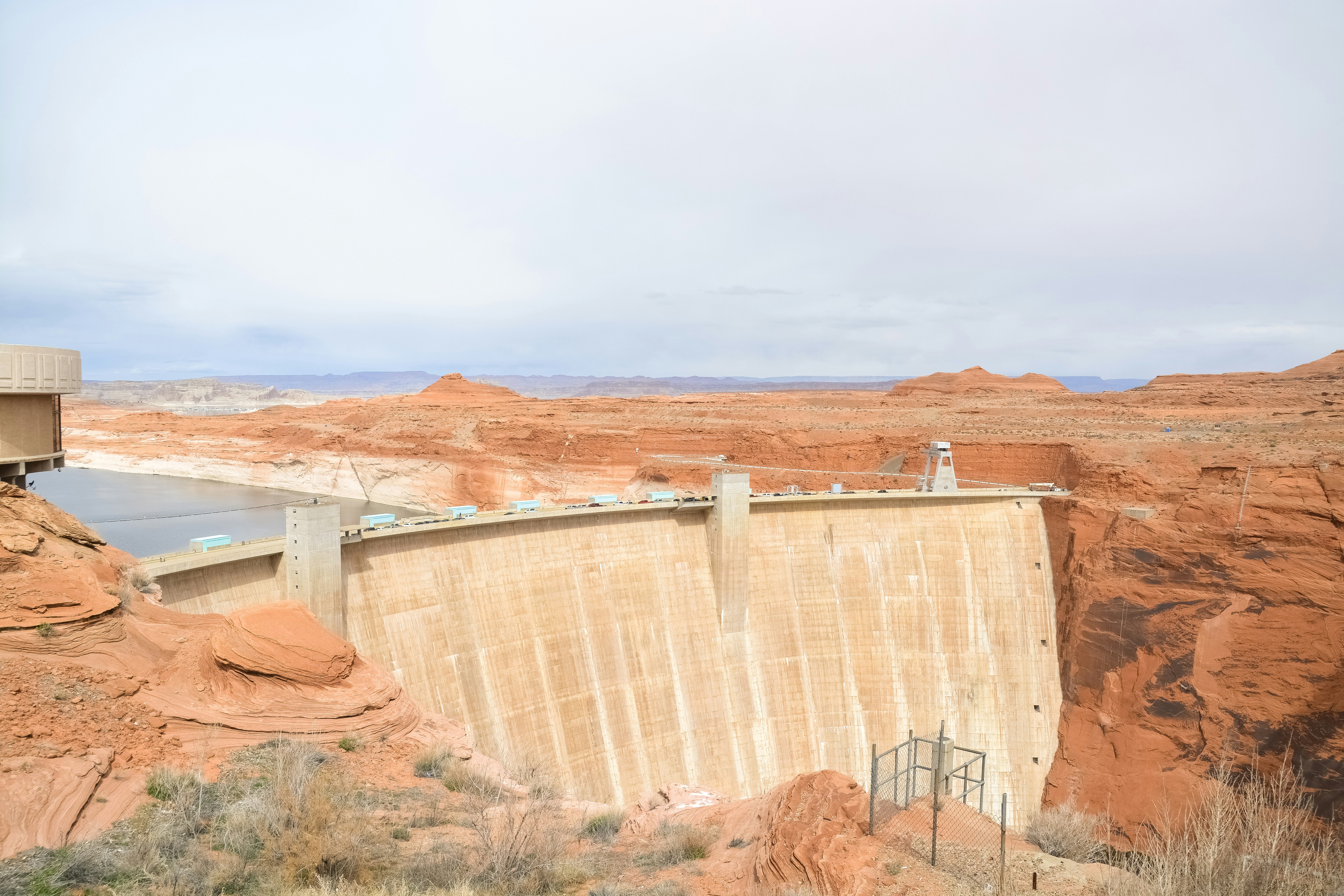 brown and white concrete dam under white sky during daytime