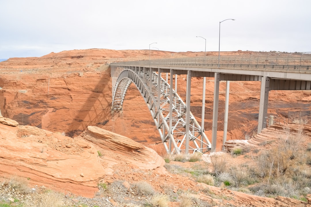 gray metal bridge over brown rock formation during daytime