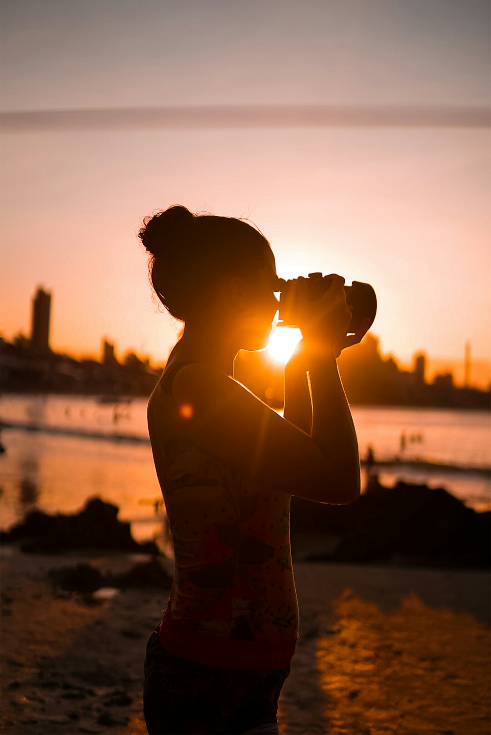 Silhouette eines Mannes, der bei Sonnenuntergang am Strand steht
