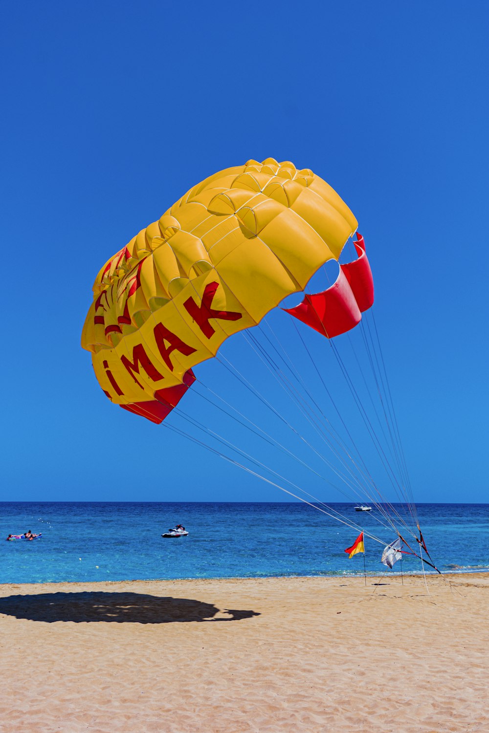yellow red and blue parachute on the beach during daytime