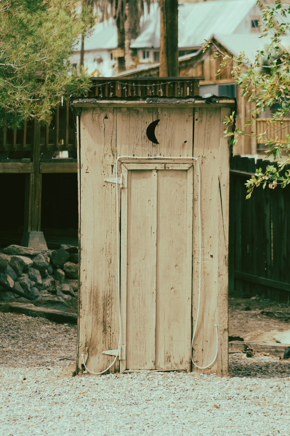 brown wooden door near green plants during daytime