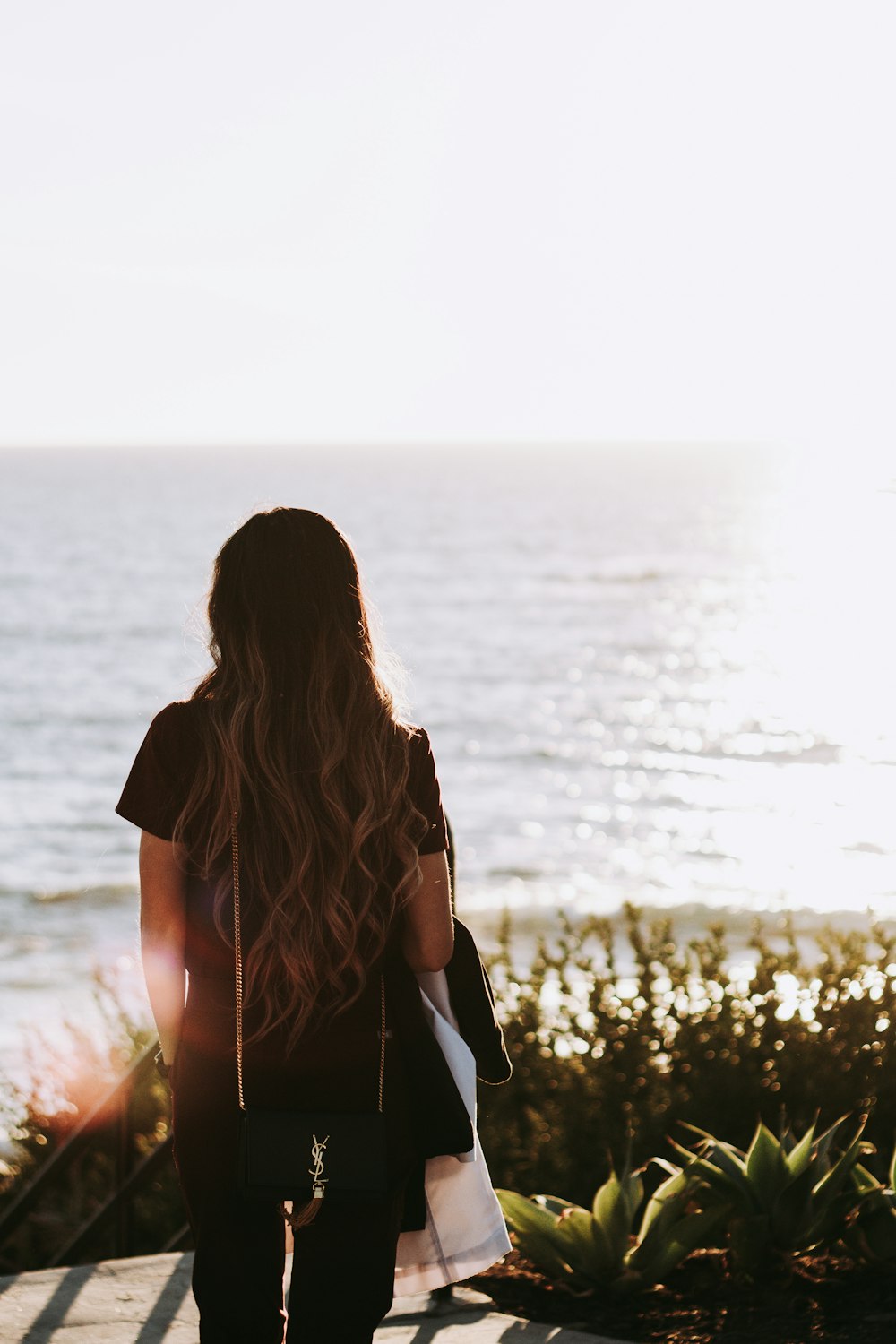 woman in black shirt standing near body of water during daytime