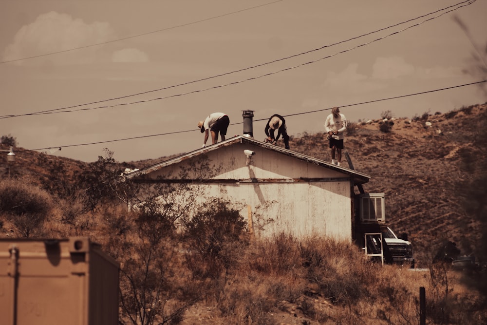 2 men standing on white concrete building during daytime