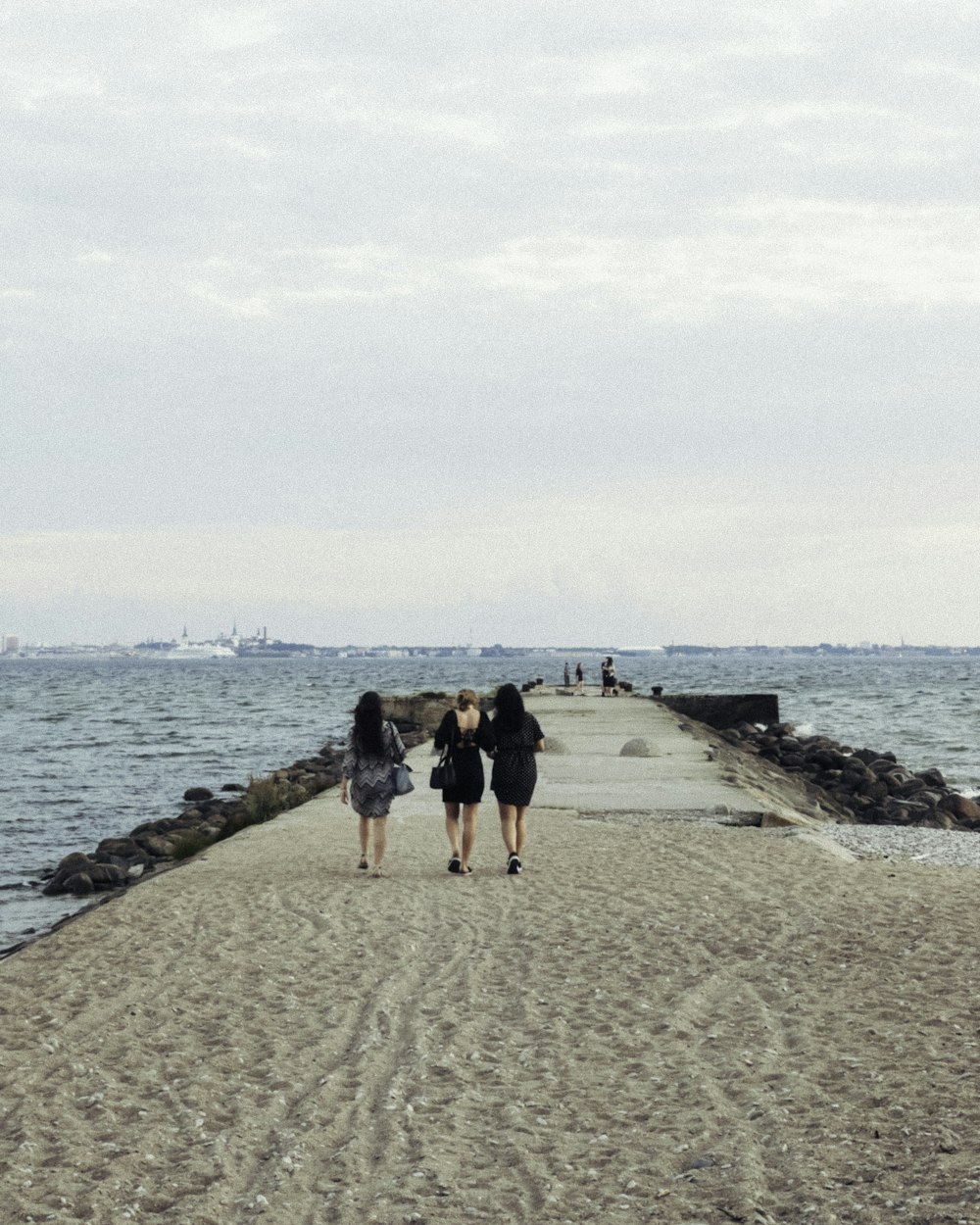 2 women walking on beach during daytime