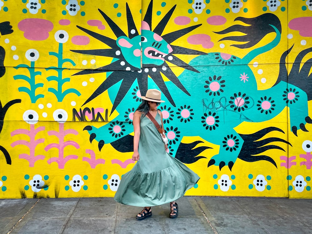 woman in white dress standing near wall with butterfly painting