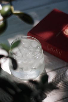 A clean glass of water placed on a kitchen counter with sunlight streaming in.