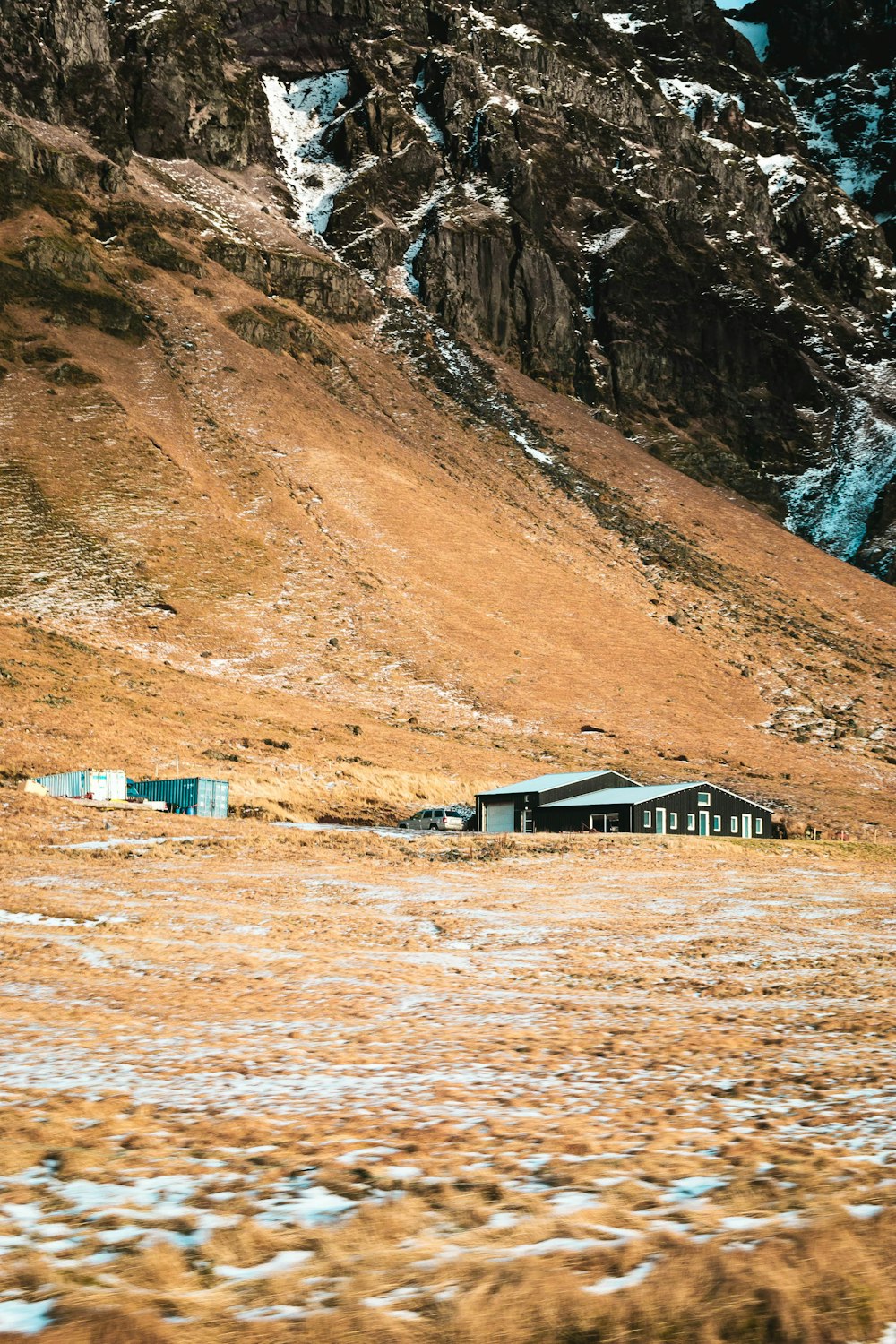 Casa di legno bianca e marrone vicino alla montagna marrone durante il giorno