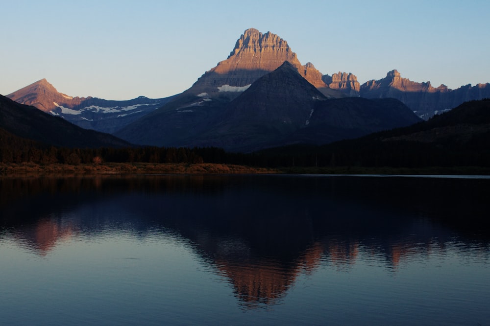 brown and white mountain near lake during daytime