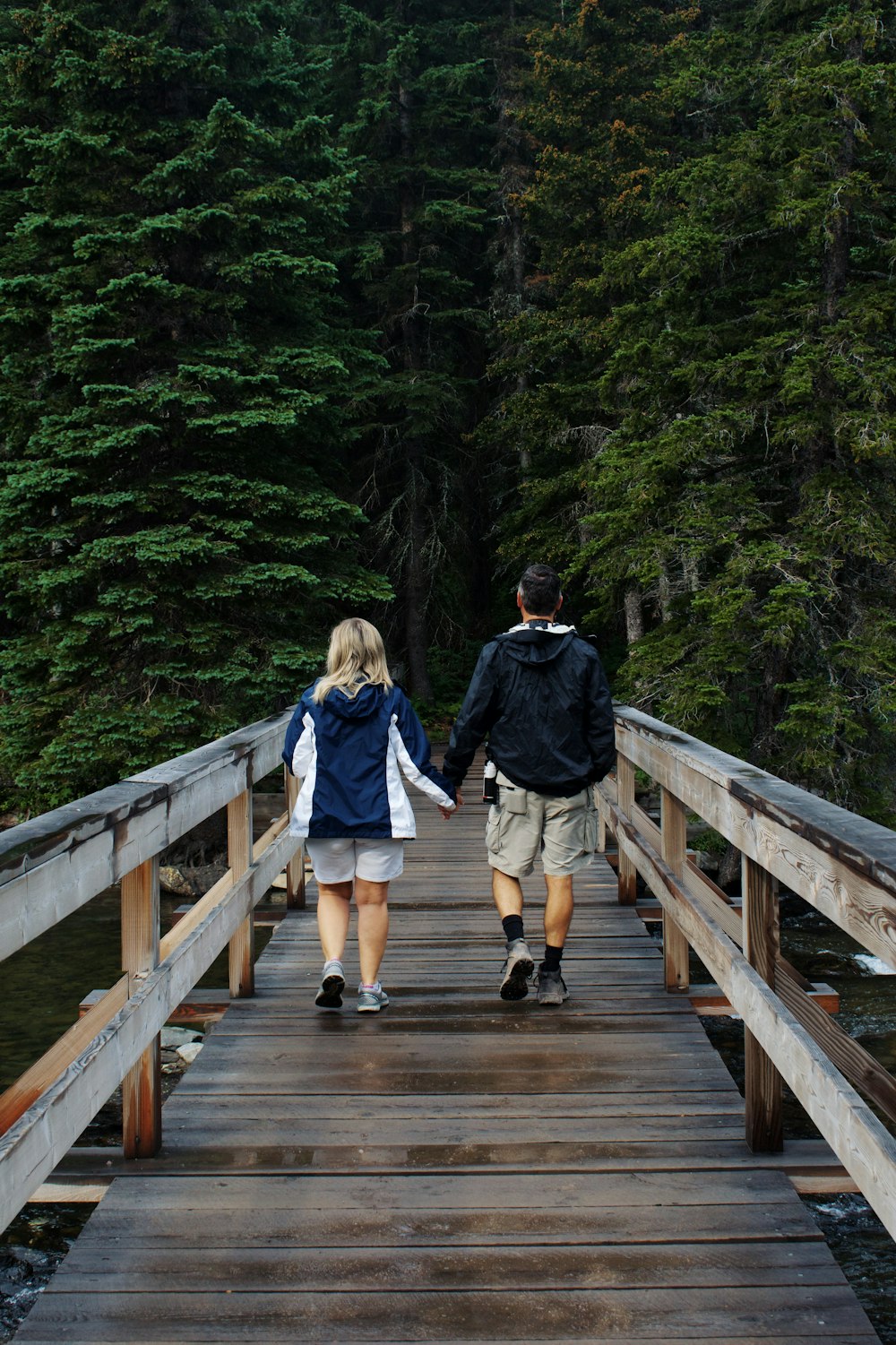 2 women walking on wooden bridge