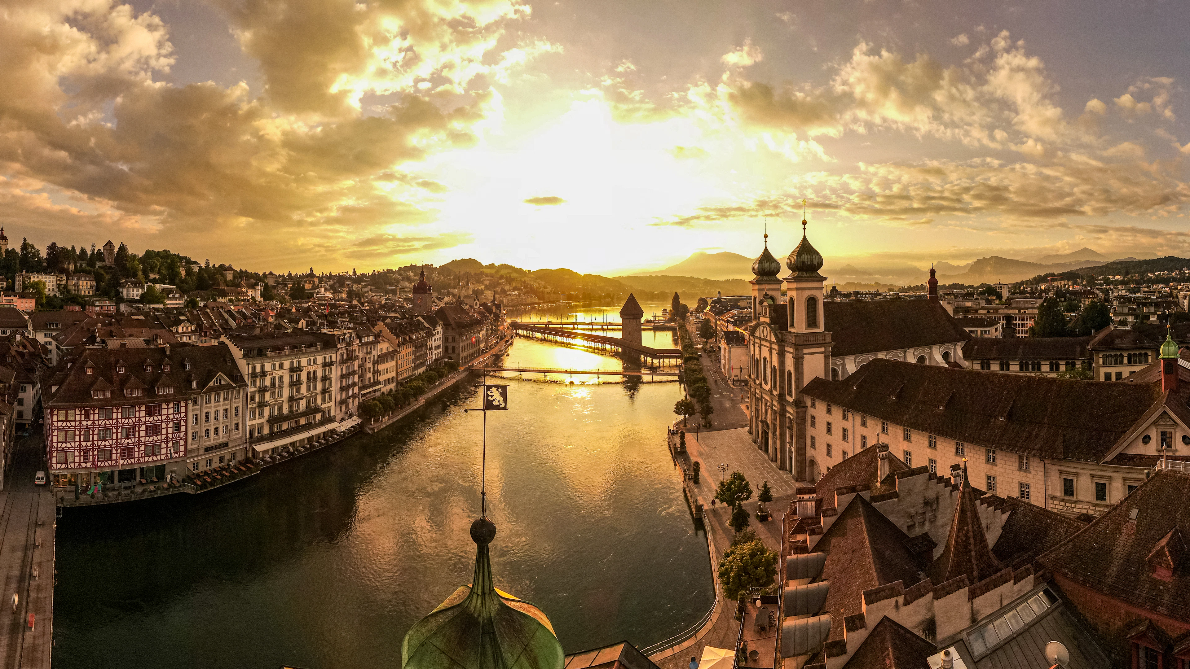 A golden sunset panorama over Lucerne's old town, the Reuss river and the Chapel Bridge's Water Tower.