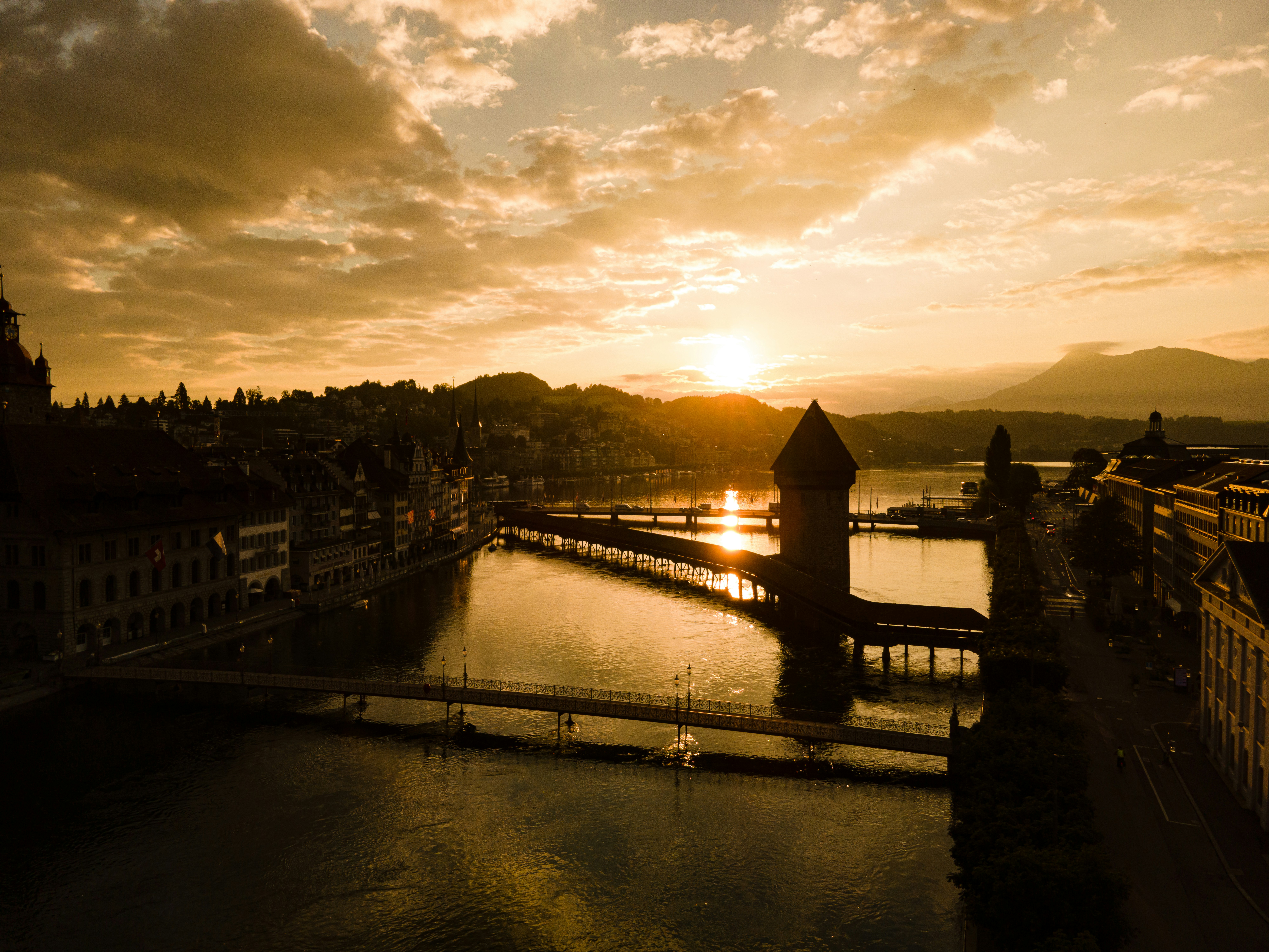 brown wooden house on water during sunset