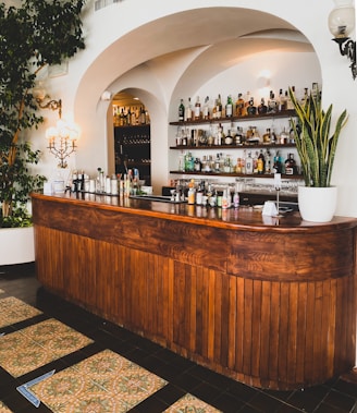 brown wooden counter desk with bottles and green plants