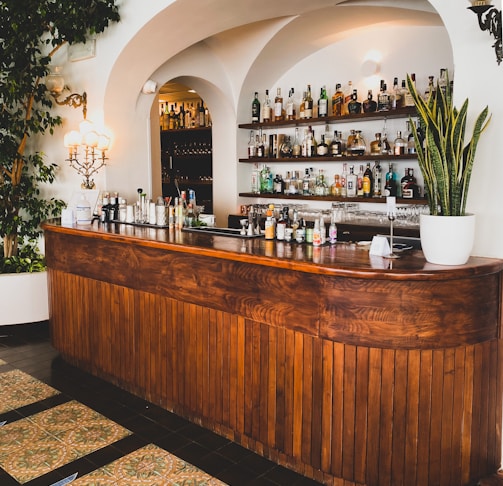 brown wooden counter desk with bottles and green plants