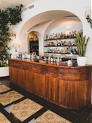 brown wooden counter desk with bottles and green plants