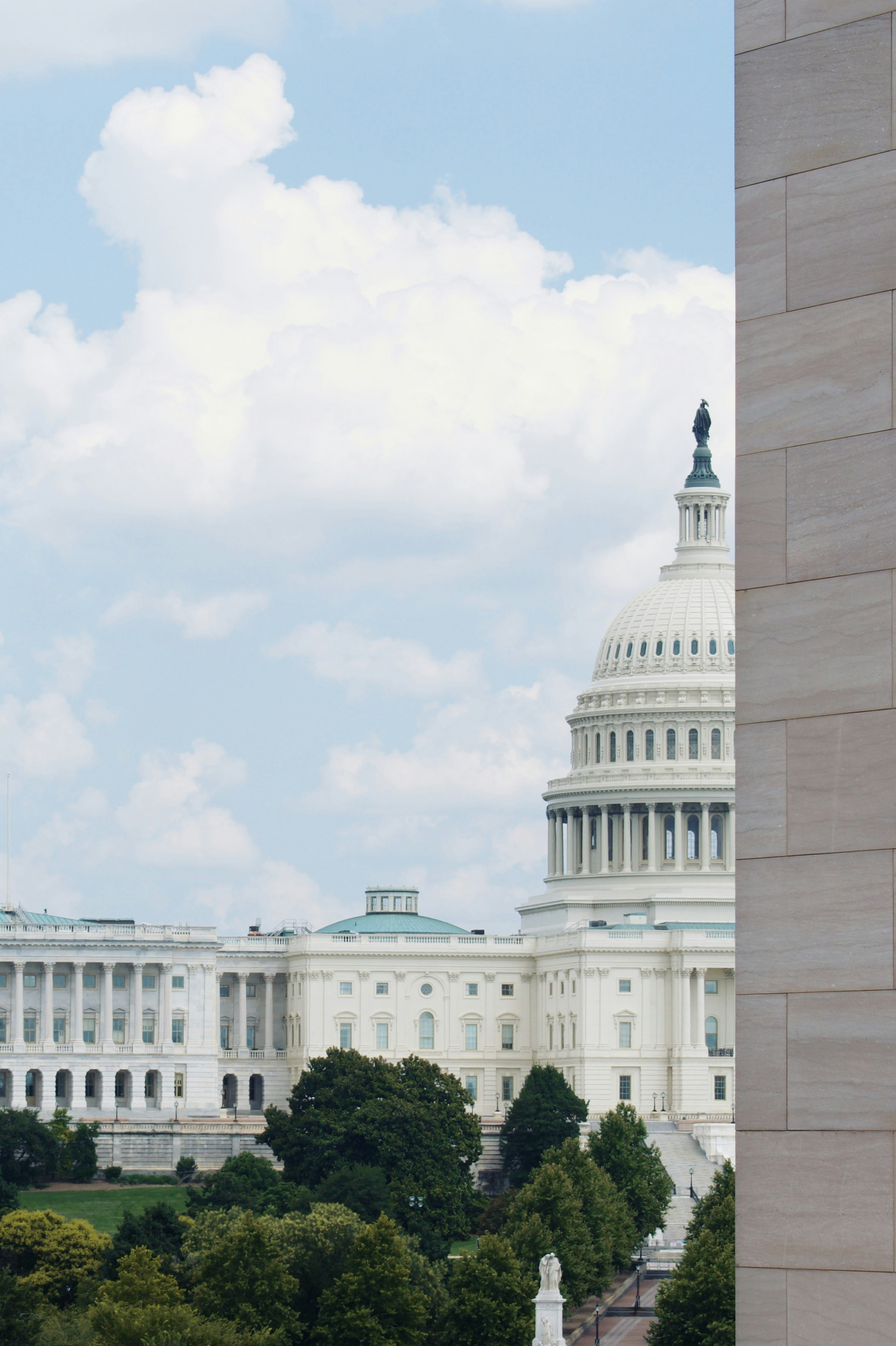 edificio in cemento bianco sotto il cielo bianco durante il giorno