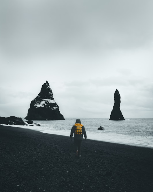 woman in yellow shirt walking on beach during daytime