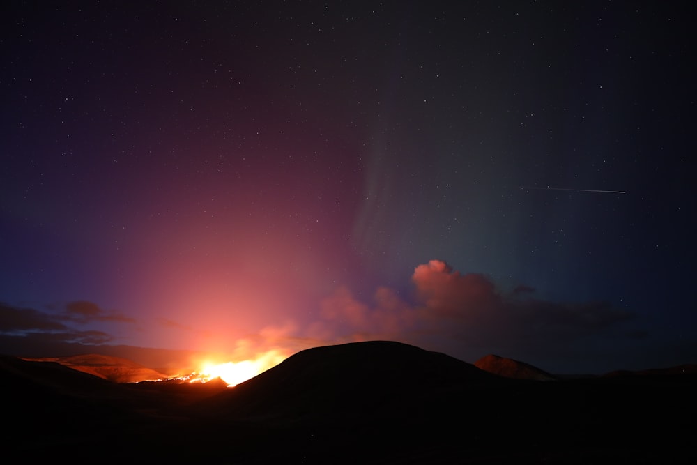 silhouette of mountain during night time