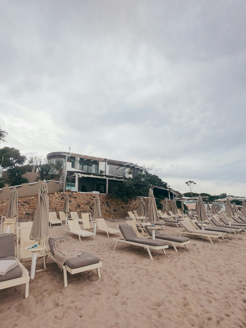 white and brown beach chairs on beach during daytime