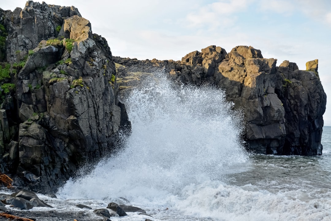 water waves hitting rock formation during daytime