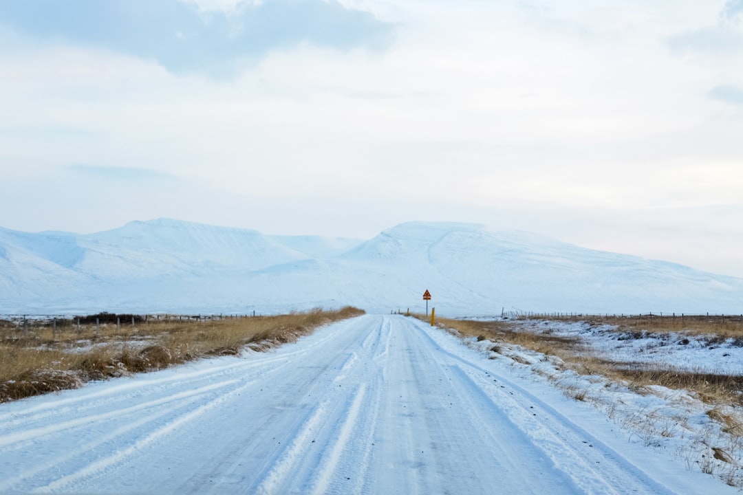 person walking on snow covered road during daytime