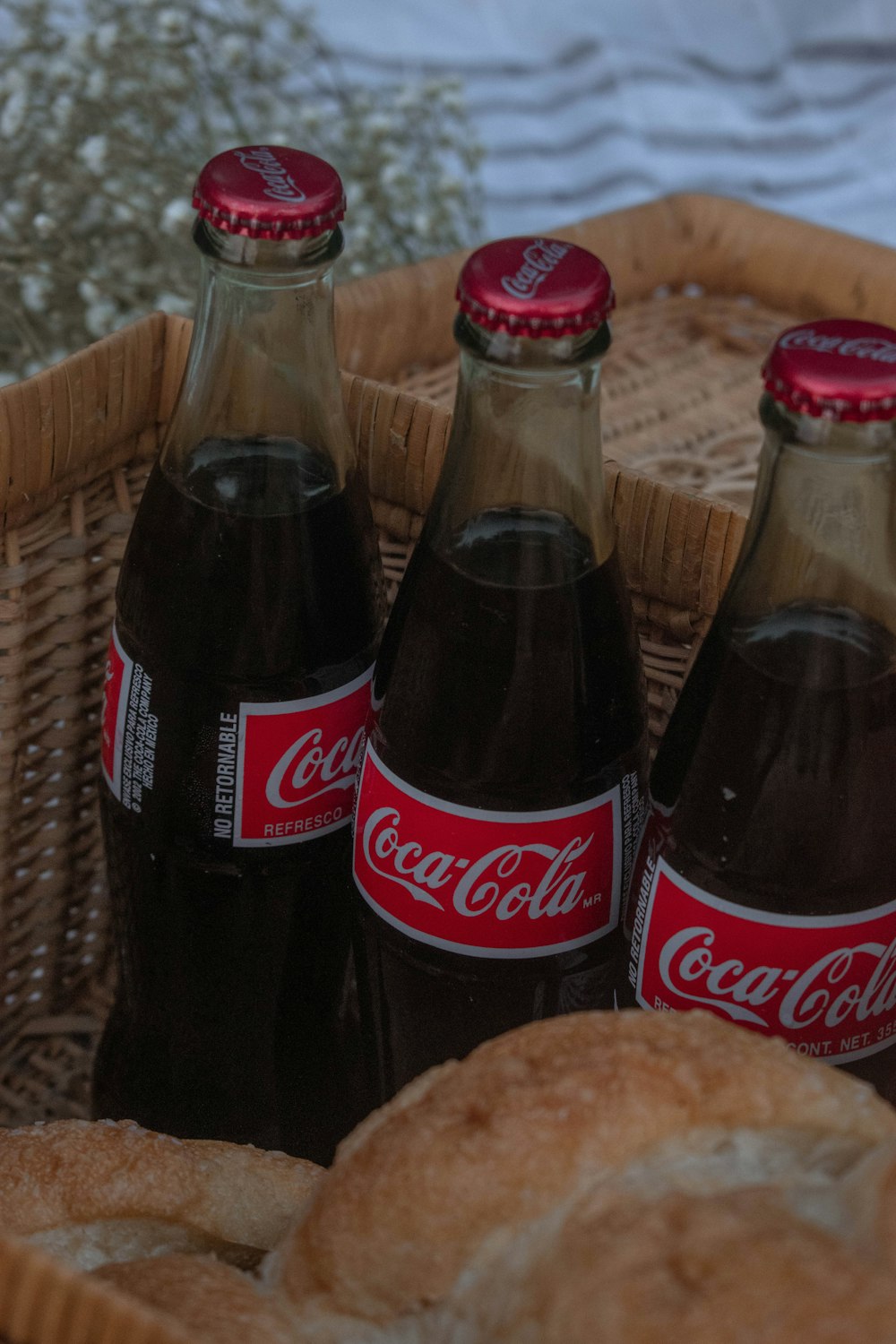 2 coca cola bottles on brown woven table