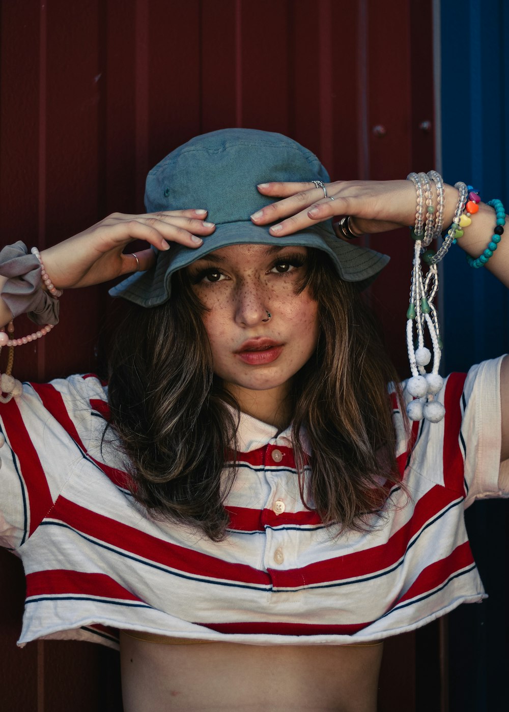 Donna in polo a righe rosse, bianche e nere che indossa un cappello blu