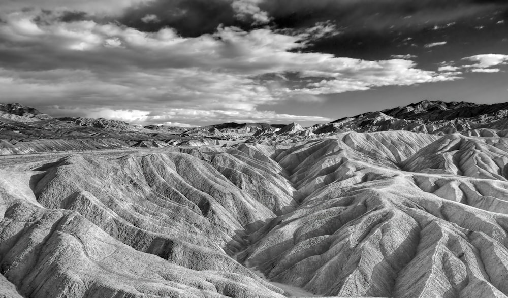 Photo en niveaux de gris d’une montagne rocheuse sous un ciel nuageux