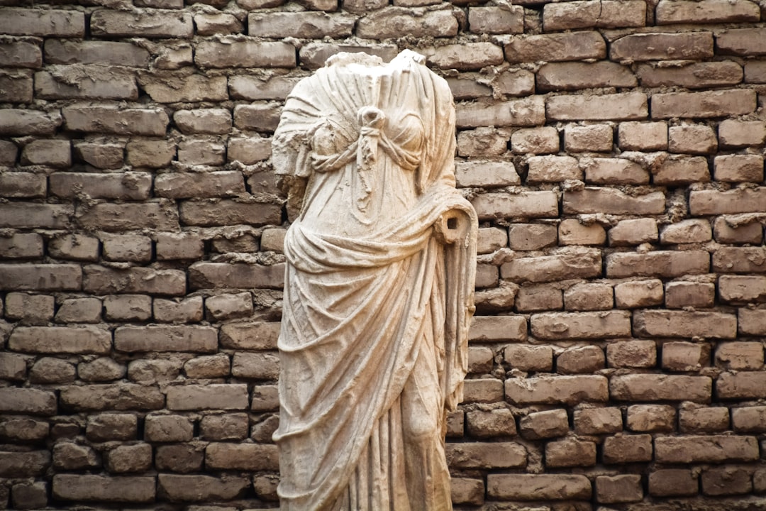 white angel statue on brown brick wall