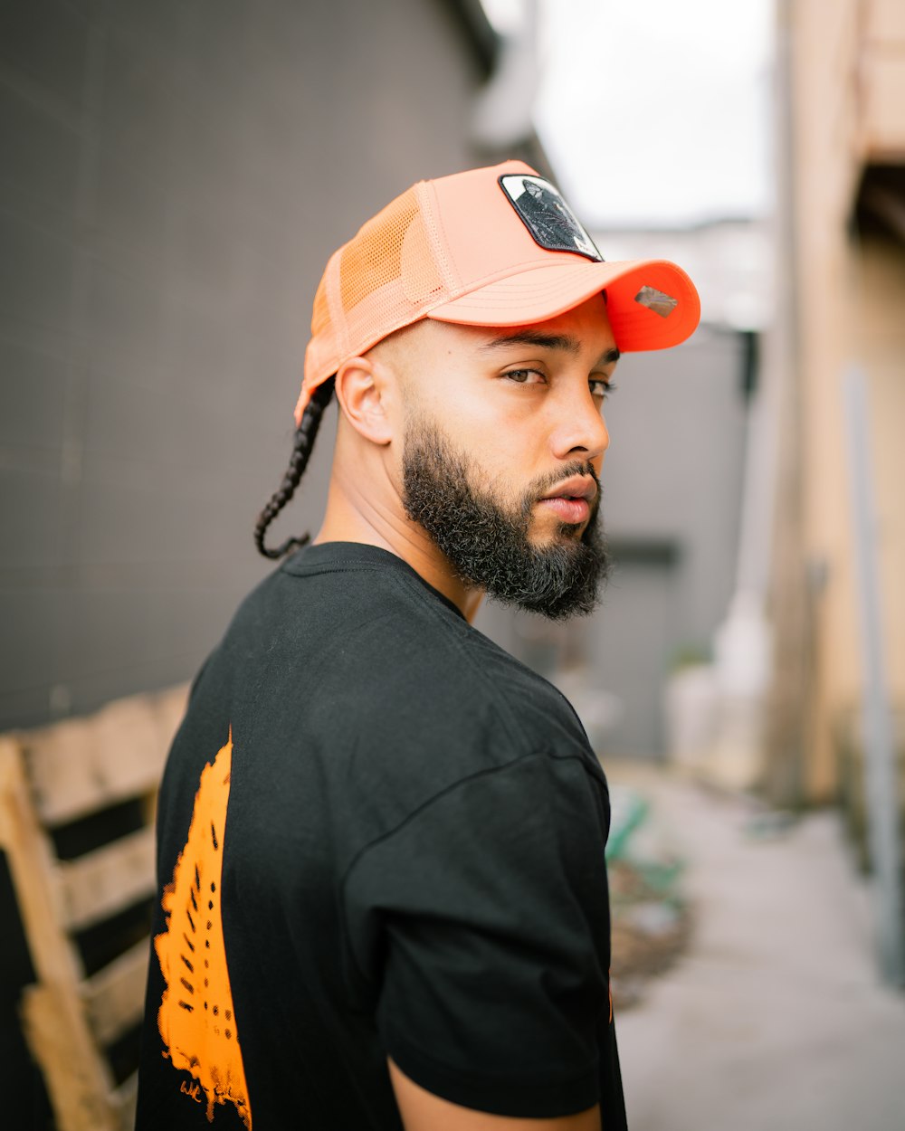 man in black and yellow shirt wearing orange cap