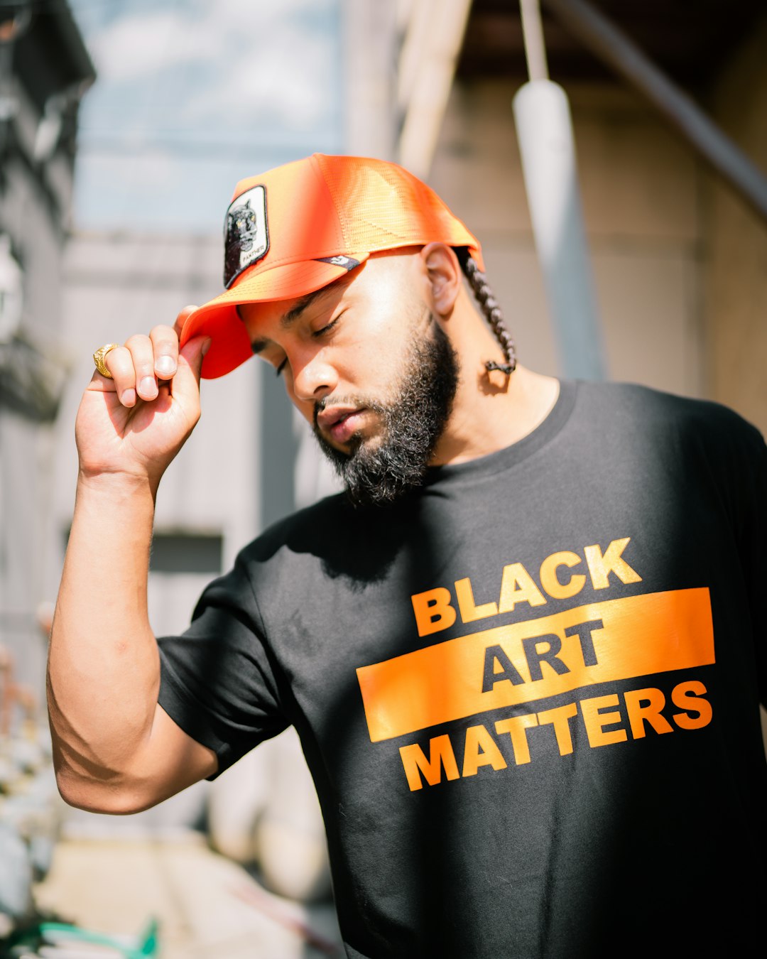man in black crew neck t-shirt wearing orange cap