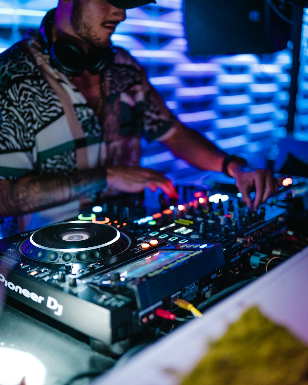 man in black and white floral button up shirt playing dj mixer