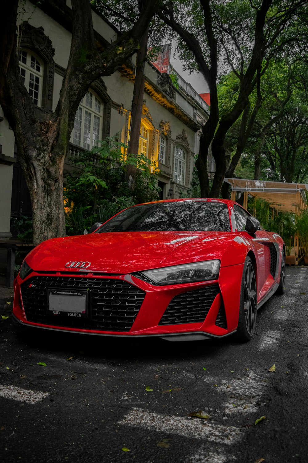 Roter Audi R 8 tagsüber in der Nähe grüner Bäume geparkt