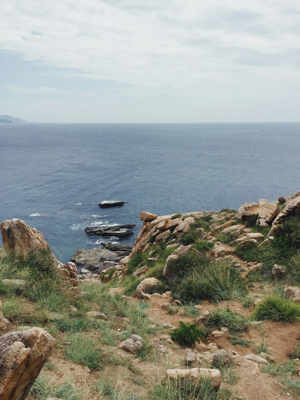 brown rocky shore near body of water during daytime