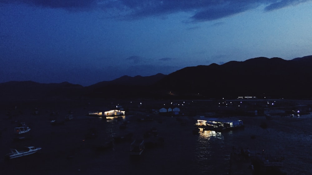 barca bianca e marrone sull'acqua sotto il cielo blu durante la notte