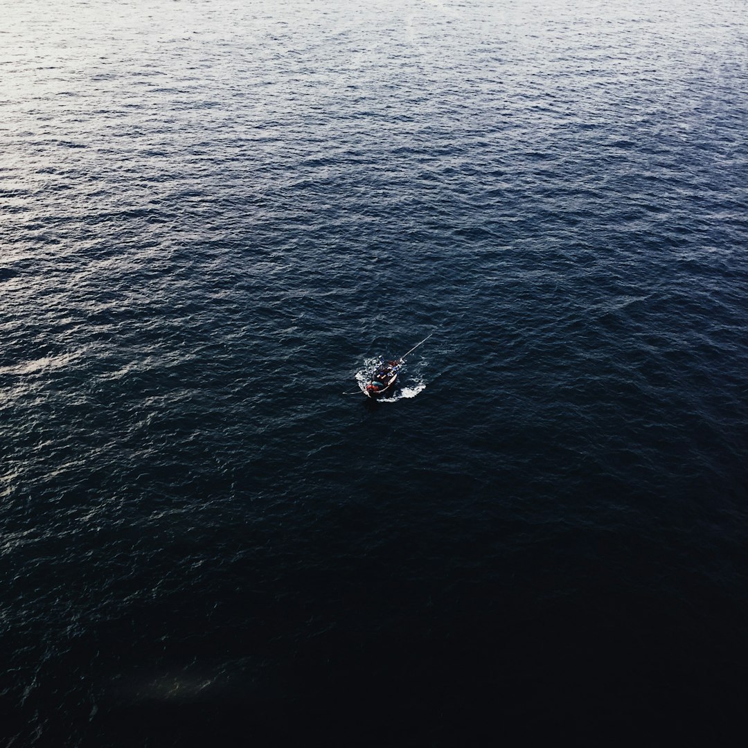 person riding on white boat on blue sea during daytime