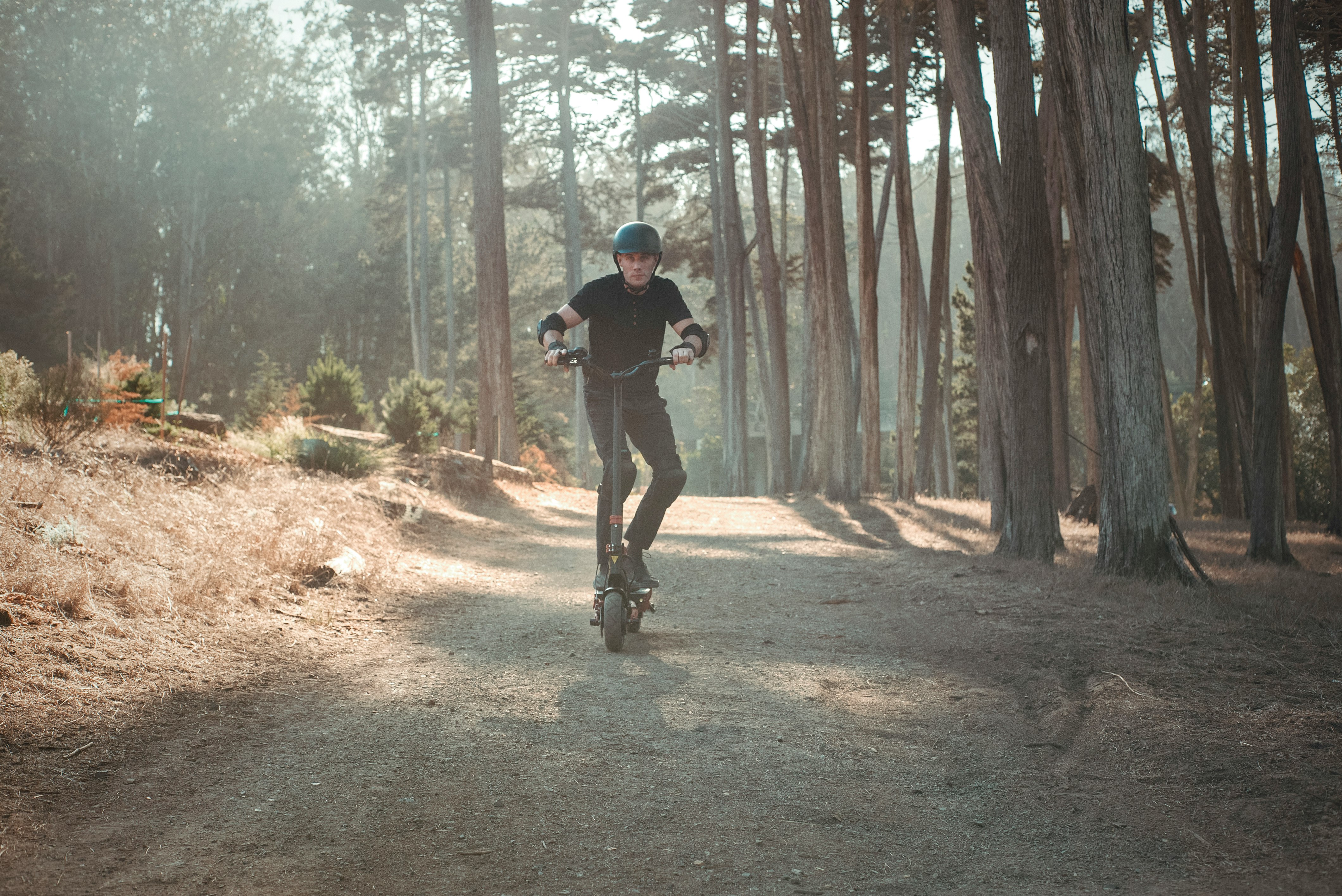 man in black t-shirt and black pants running on forest during daytime