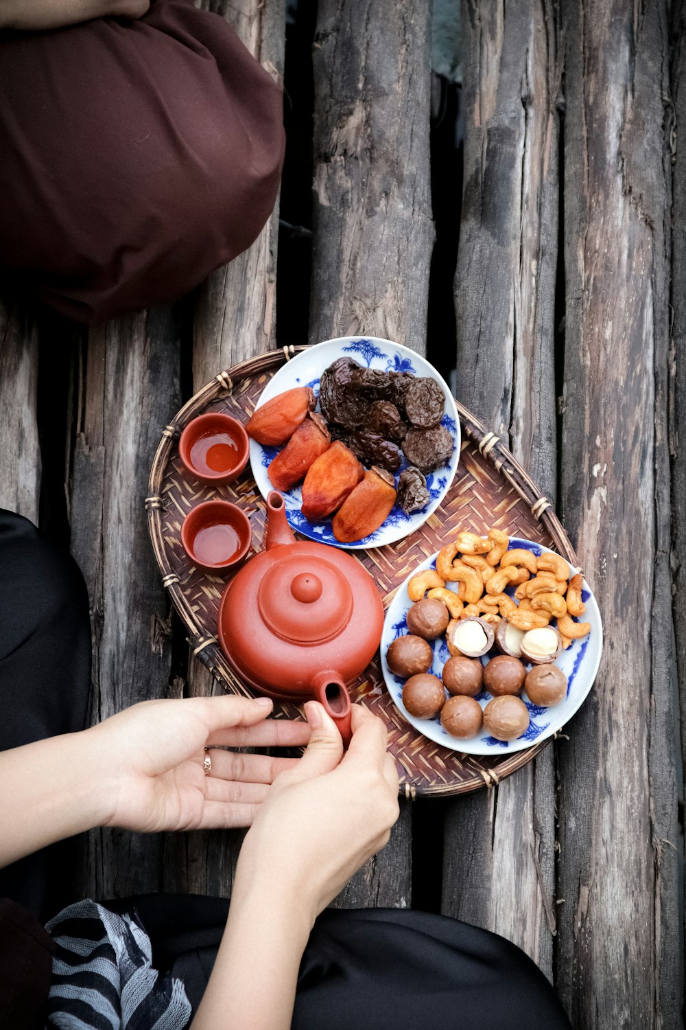 person holding orange fruit on blue ceramic bowl